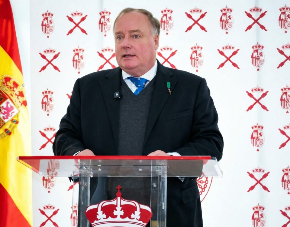 Don Carlos Javier de Borbón Parma, en el centro de la imagen con un fondo con su escudo real y cruces de borgoña junto a una bandera de España, pronuncia su discurso en Madrid el 14 de marzo de 2026